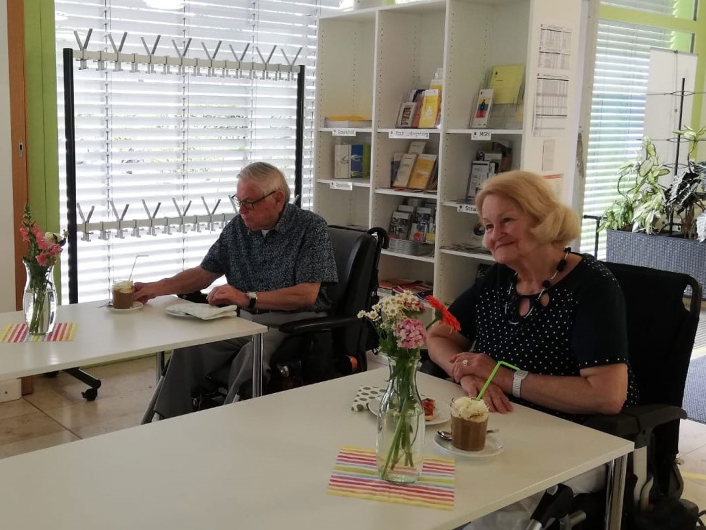 Das Foto zeigt das Café L’ink in Grünbühl-Sonnenberg. Am Tisch sitzten sind zwei Senioren, die sich Kaffee und Kuchen schmecken lassen.