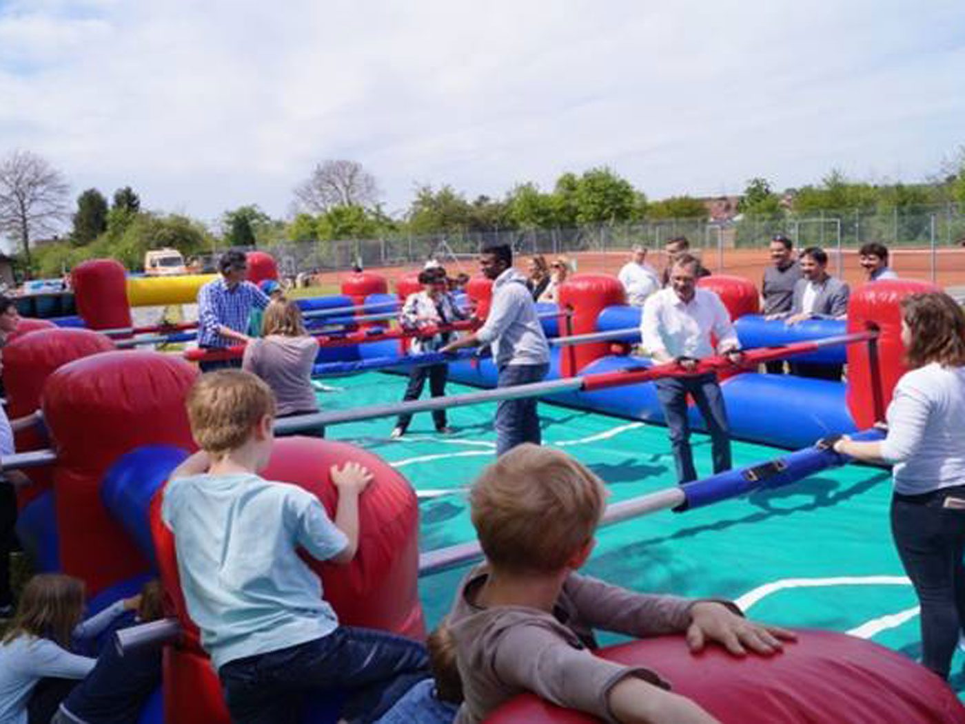 Das Foto zeigt einen menschengroßen Kicker in Poppenweiler. Die Figuren werden von echten Menschen gespielt. Um das aufgeblasene Spielfeld steht Publikum.