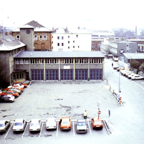 Das Foto zeigt den damaligen Rathausplatz. Ein Platz ist umrundet von Parkplätzen.